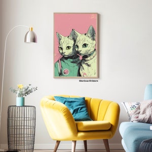 May include: A digital art print featuring two white cats wearing green and white space suits against a pink background. The text "Glorious Critters" is printed below the image.