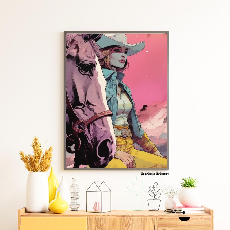 May include: A framed illustration of a woman wearing a cowboy hat and a blue denim jacket, riding a horse. The background is a pink and purple sky with clouds. The text "Glorious Critters" is at the bottom of the image.