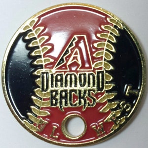 May include: A gold-colored metal coin with a red, white, and black baseball design. The coin features the Arizona Diamondbacks logo, including the team's 'A' and the words 'Diamondbacks'.
