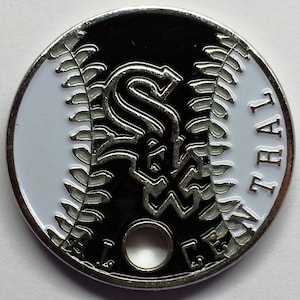 May include: A black and white baseball-themed coin with a silver-colored Chicago White Sox logo and the word "TRIAL" written around the edge.