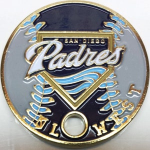 May include: A gold-colored metal coin with a blue and white San Diego Padres logo. The logo is a baseball diamond with the words "San Diego Padres" in white lettering. The coin has a hole in the center and the words "Lowest Prices" around the edge.