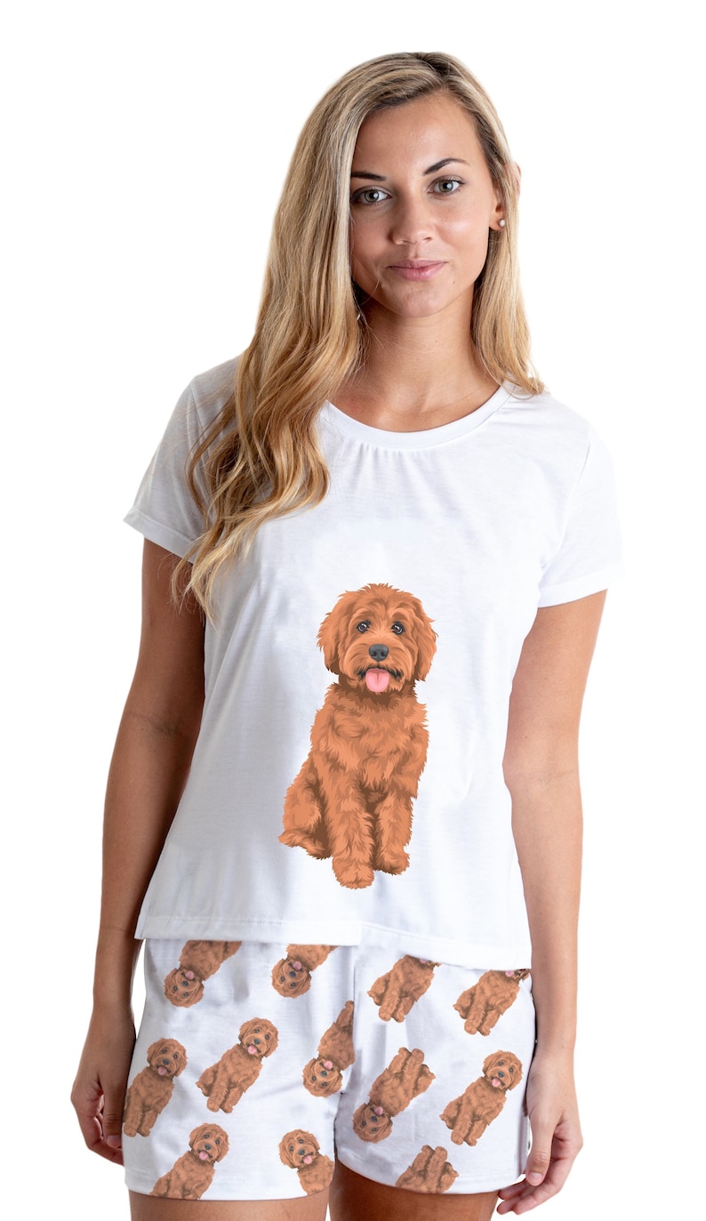 May include: White pajamas with a brown dog print. The top has a single large dog image and the shorts have a repeating pattern of smaller dogs.