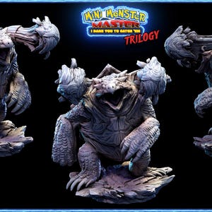 May include: A collection of three detailed monster figurines. The central figure is a large, gray, reptilian creature with an open mouth. The figures are on rocky bases, with the text "Mini Monster Master Trilogy" above.