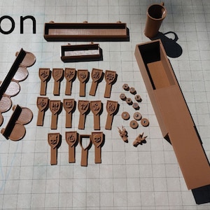 May include: A brown 3D printed set of game pieces, including a box, tiles, and figures. The set is labeled "Addon Set".