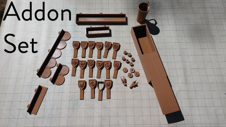 May include: A brown 3D printed set of game pieces, including a box, tiles, and figures. The set is labeled "Addon Set".