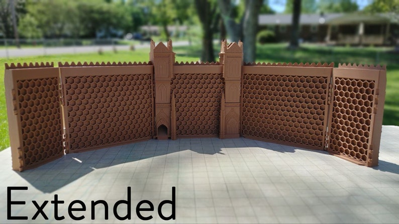 May include: A brown, modular, honeycomb-patterned wall with two towers, extended to its full length. The wall is made of plastic and has a textured surface. The text "Extended" is visible at the bottom of the image.