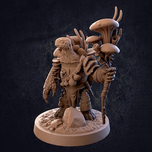 May include: A brown painted miniature figurine of a turtle-like creature wearing armor and holding a staff with mushroom-shaped tops. The figurine is standing on a round base.