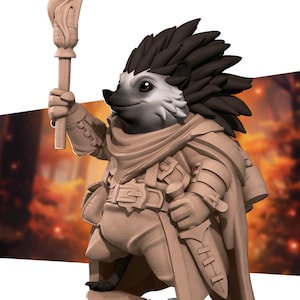 May include: A detailed figurine of a hedgehog character, holding a torch and a dagger. The hedgehog has a light gray face, dark brown quills, and is wearing a tan cloak and belt. The background is blurred with warm colors.