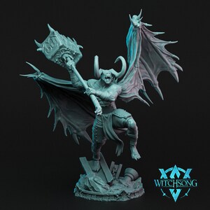 May include: A gray, detailed miniature figurine of a demon with horns, wings, and a large hammer. The demon is standing on a rocky base with the text "WITCHSONG" in a blue and white logo.