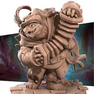 May include: A brown, sculpted figurine of a turtle-like creature wearing a hat and playing an accordion. The creature has a large, toothy grin and is holding the accordion with both hands.