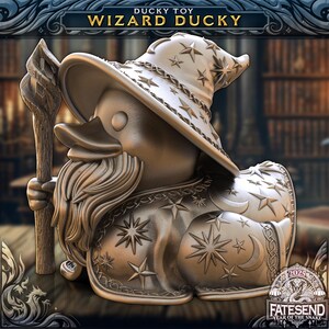 May include: A metallic bronze-toned duck figurine dressed as a wizard, wearing a star-patterned hat and robe, holding a wooden-textured staff. The text DUCKY TOY WIZARD DUCKY appears at the top, and FATESEND 2025 YEAR OF THE SNAKE is at the bottom.