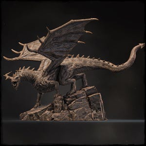 May include: A detailed bronze sculpture of a dragon with outstretched wings, perched on a rocky base. The dragon has a fierce expression and sharp claws.