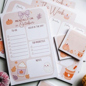 Pu&ograve; includere: Un set di planner cartacei e foglietti adesivi a tema autunnale con zucche, foglie, un fantasma e una tazza di caff&egrave;. Il planner include sezioni per To-Do, Focus of the Day, Top Priorities e Notes, con il testo Mentally I'm in October.