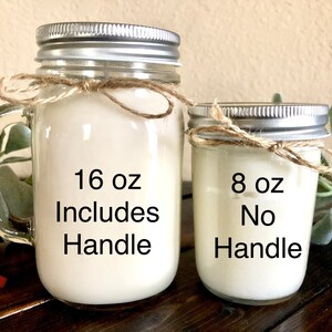 May include: Two mason jar candles, one with a handle and one without. The larger candle is 16 oz and includes a handle. The smaller candle is 8 oz and does not have a handle.
