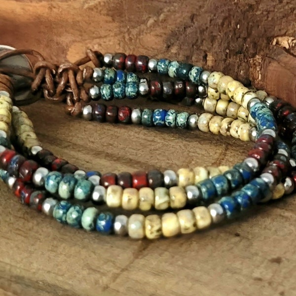 Four-strand Boho-style bracelet made with Picasso beads in garnet, montana blue, and yellow canary with silver stainless steel spacer bead.