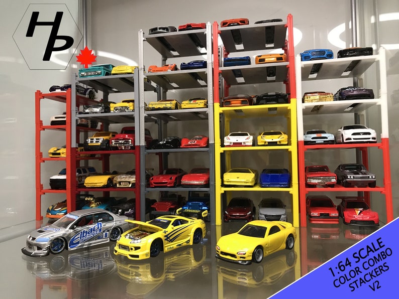Peut inclure: Un ensemble de quatre empileurs de voitures en m&eacute;tal multicolores, chacun avec cinq niveaux, contenant une vari&eacute;t&eacute; de voitures miniatures &agrave; l'&eacute;chelle 1:64. Les empileurs sont &eacute;tiquet&eacute;s "1:64 Scale Color Combo Stackers V2".
