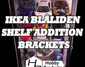 Puede incluir: Una vitrina de cristal negra con estantes llenos de coches de juguete, figuras y un libro. La vitrina tiene una etiqueta blanca en la parte delantera que dice "Hobby Products". El texto "IKEA BLÅLIDEN SHELF ADDITION BRACKETS" está superpuesto a la imagen.