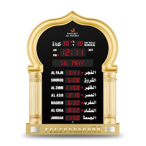 May include: A gold-coloured digital prayer clock with a black display. The clock shows the time, date, and prayer times in red. The clock has the text "AL-FATIHA" at the top and includes temperature and DST indicators.