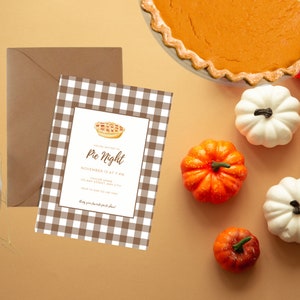May include: A brown and white checkered invitation for a Pie Night party. The invitation features a watercolor illustration of a pie with a brown crust and a red filling. The text on the invitation reads "You are invited to Pie Night, November 13 at 7 PM, Taylor Home, 123 Any Street Any City, RSVP to 123-456-7890, Bring your favorite pie to share!"