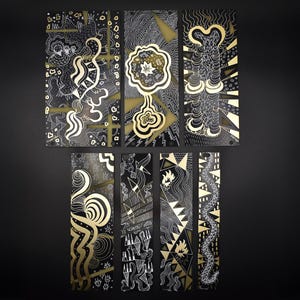 Könnte beinhalten: Eine Sammlung abstrakter Kunstpaneele in Schwarz und Gold. Die Paneele zeigen komplizierte weiße Strichzeichnungen und goldene Akzente. Die Kunstwerke umfassen geometrische Formen, organische Formen und stilisierte Figuren. Die Gesamtästhetik ist modern und dekorativ.