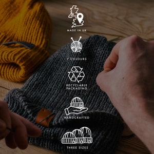 May include: A gray knitted beanie hat with a leather label. The hat is being held by a hand. The image also shows a yellow knitted beanie hat and several icons with text: "Made in UK", "7 Colours", "Recyclable Packaging", "Handcrafted", and "Three Sizes".