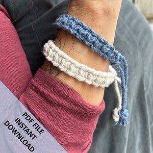 May include: Two macrame bracelets, one light blue and one off-white, are displayed on a wrist. The bracelets are made of thick, textured yarn. The image also includes the text "PDF FILE INSTANT DOWNLOAD" in white.