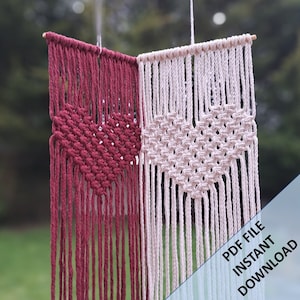 May include: Two macrame wall hangings with heart designs. The left one is burgundy and the right one is cream. The text "PDF FILE INSTANT DOWNLOAD" is in the bottom right corner.