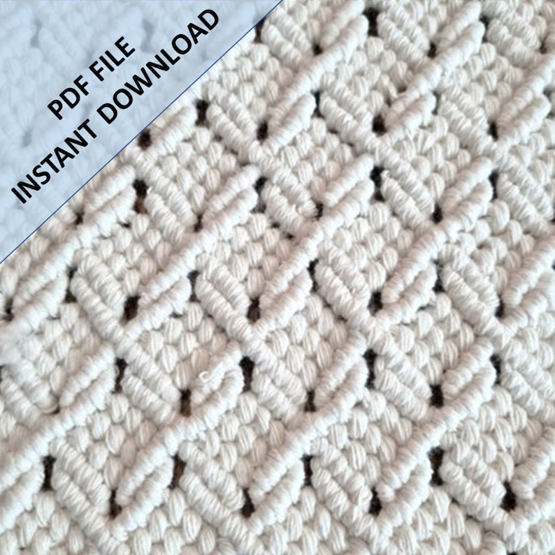 May include: A close-up of a white macrame wall hanging with a diamond pattern. The macrame is made with thick cotton cord and has a natural, rustic look.