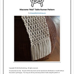 Pode incluir: Um corredor de mesa de macram&eacute; branco com franjas sobre uma superf&iacute;cie de vime. O padr&atilde;o &eacute; chamado de "Mail" e &eacute; de ButOneString.com. Copyright &copy; 2022 ButOneString. Todos os direitos reservados. Para uso pessoal apenas. Nenhuma parte deste documento pode ser reproduzida, distribu&iacute;da ou revendida sem a permiss&atilde;o do autor. N&atilde;o &eacute; permitido vender qualquer produto de macram&eacute; feito usando este padr&atilde;o ou adapta&ccedil;&atilde;o do mesmo. Este padr&atilde;o &eacute; apenas para uso pessoal.