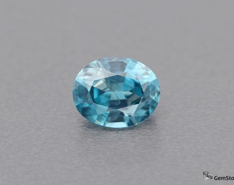 Può includere: Una pietra preziosa ovale di colore blu-verde con sfaccettature.