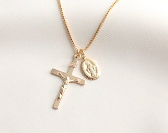 May include: A gold chain necklace with a gold cross pendant and a gold oval pendant featuring a religious image.