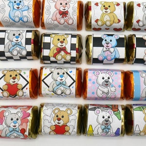 May include: A collection of individually wrapped chocolate candies. Each candy wrapper features a different cartoon teddy bear design, with various colors and patterns. The wrappers have gold foil edges and are arranged on a white surface.
