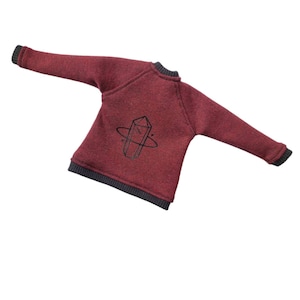 May include: A maroon sweatshirt with a black graphic of a crystal inside a circle on the back.