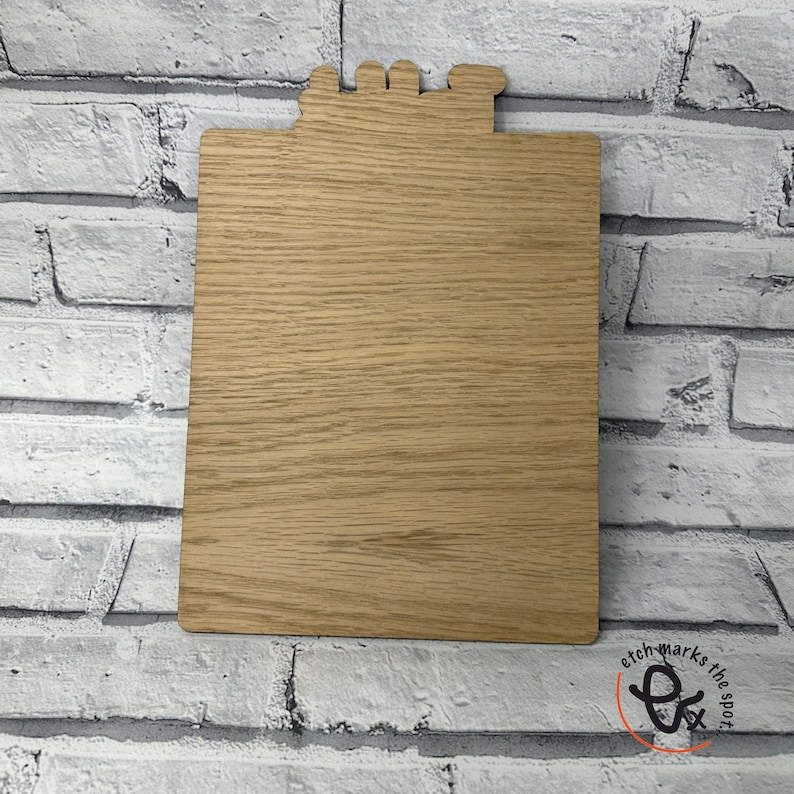 May include: A wooden clipboard with a blank surface. The clipboard has a decorative top with a cutout design.