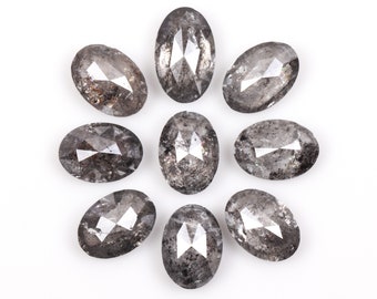 Pode incluir: Nove diamantes de forma oval, de cor cinza escuro, facetados, dispostos em um círculo sobre um fundo branco.