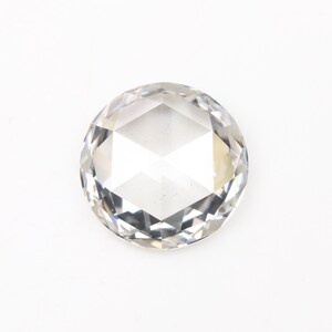 May include: A clear, round-cut gemstone with multiple facets, reflecting light. The gem is set against a white background, highlighting its clarity and brilliance. This gemstone is suitable for jewelry making.