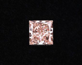 May include: A square-shaped, light pink diamond with a faceted cut. The diamond is set against a black background.