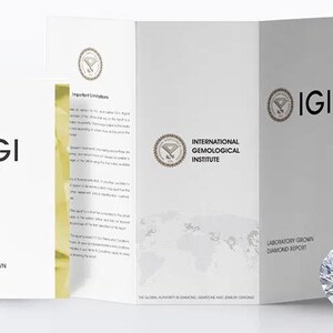 Puede incluir: Un diamante brillante y brillante junto a un folleto blanco con el logotipo y el texto de IGI. El folleto está etiquetado como "Laboratory Grown Diamond Report" e "International Gemological Institute". El diamante tiene muchas facetas.