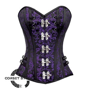Puede incluir: Un cors&eacute; morado y negro con hebillas plateadas y un patr&oacute;n floral. El cors&eacute; tiene un escote de coraz&oacute;n y est&aacute; hecho de una tela satinada.