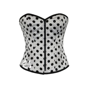 May include: A white strapless corset with black polka dots and a black zip down the front.