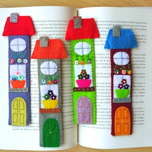 May include: Set of five felt house-shaped bookmarks. Each bookmark features a different color house with a window, door, and flower pot. The houses are arranged in a row on a book.