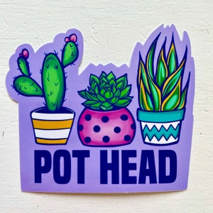May include: Purple sticker with three potted plants and the text "POT HEAD". The plants are a cactus, a succulent, and a snake plant. The cactus is green with yellow and white stripes on the pot. The succulent is green with pink polka dots on the pot. The snake plant is green and yellow with blue and white stripes on the pot.
