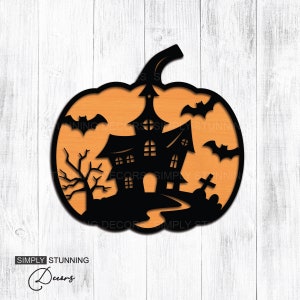 May include: A black Halloween-themed pumpkin decoration with a haunted house silhouette, bats, and a graveyard scene. The pumpkin has an orange interior and the text "SIMPLY STUNNING Decors".