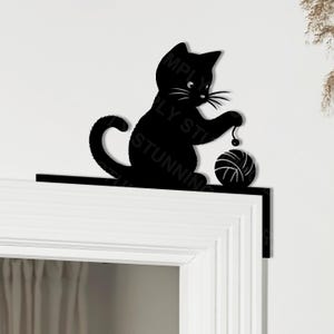 Peut inclure: Silhouette noire d'un chat jouant avec une pelote de laine. Le chat est perché sur une corniche noire, avec le texte "SIMPLY STUNNING" visible. Idéal pour la décoration intérieure.