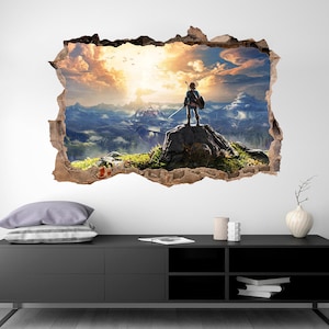 May include: A wall decal featuring a video game character standing on a mountaintop with a sword in hand. The character is looking out at a vast, cloudy landscape. The decal is designed to look like a hole in the wall, creating a 3D effect.