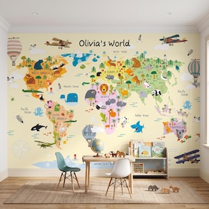 Może przedstawiać: Fototapeta z mapą świata zatytułowaną Olivia's World, przedstawiająca kontynenty w różnych kolorach z ilustracjami zwierząt, drzew, balonów na ogrzane powietrze i samolotów. Mapa zawiera nazwy oceanów i kontynentów na jasnym tle.