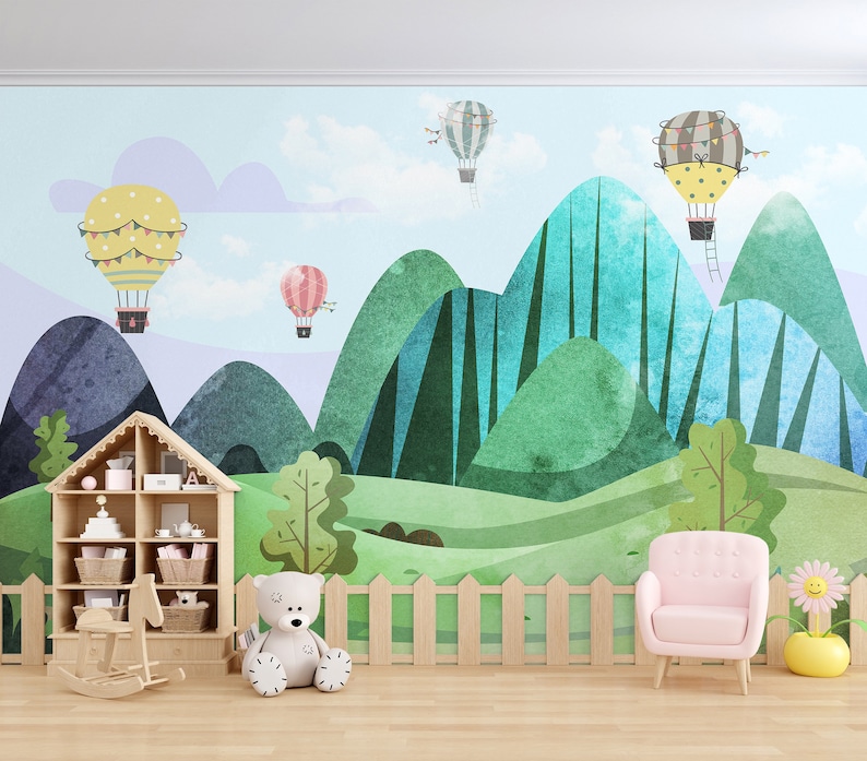 K&ouml;nnte beinhalten: Ein Spielzimmer f&uuml;r Kinder mit einem farbenfrohen Wandbild mit Hei&szlig;luftballons und Bergen. Im Vordergrund befinden sich ein h&ouml;lzerner Spielzeugregal mit einem Schaukelpferd, einem Teddyb&auml;r und einem rosa Sessel.
