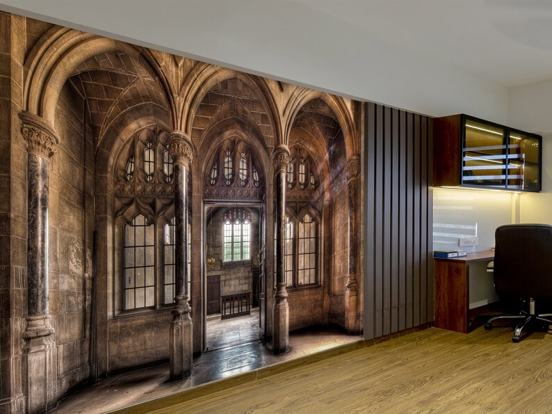 May include: A wall mural depicting a detailed, aged stone gothic cathedral interior with arched doorways and windows. The mural is installed in a room with wood flooring and a modern desk setup.