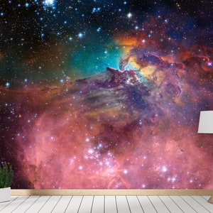 Puede incluir: Una nebulosa colorida con un esquema de colores rosa, naranja y azul. La nebulosa est&aacute; llena de estrellas y tiene un fondo oscuro.