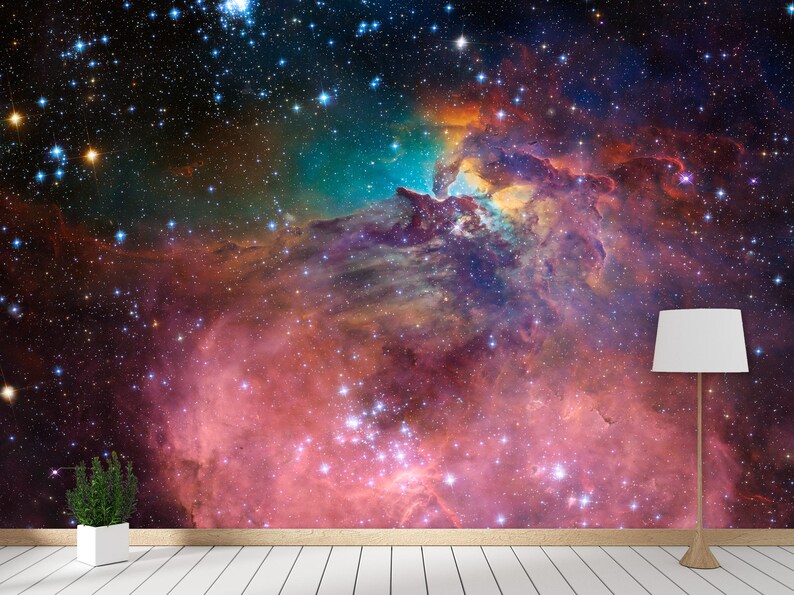 Puede incluir: Una nebulosa colorida con un esquema de colores rosa, naranja y azul. La nebulosa est&aacute; llena de estrellas y tiene un fondo oscuro.